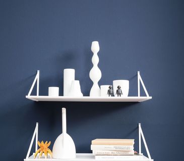 Weißes Wandboard vor dunkelblauer Wand