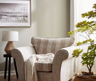 Beiger Fernsehsessel im Landhausstil mit weißer Decke in heller Umgebung