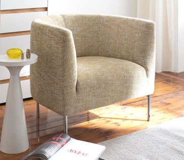 Zitronengelber Sessel vor weiß-brauner Kommode und einem weißen Beistelltisch mit gelber Vase