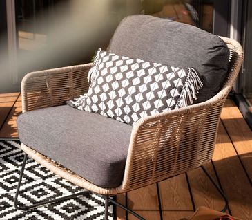 Sessel für Balkon und Garten mit grauen Polstern.