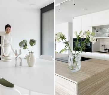 Ein großzügiger Essbereich mit weißem Tisch und weißen Stühlen und eine moderne Inselküche