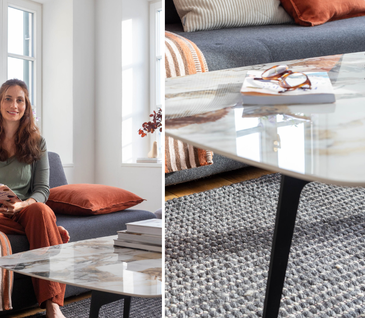 Nicole Zweig sitzt auf Sofa neben Couchtisch mit Marmorplatte.