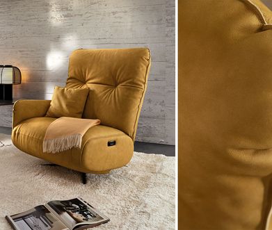 Senfgelber Sessel vor grauer Betonwand auf beigem Teppich mit schwarzem Beistelltisch.