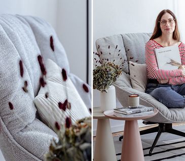 Detailansicht von Lehne eines hellgrauen Sessels und Frau sitzt mit Buch in einem Sessel.