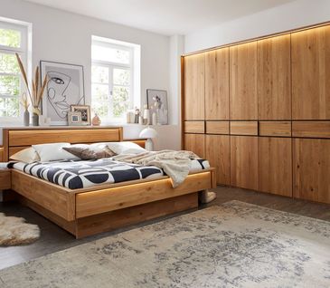 Bett und Kleiderschrank aus massiver Eiche im modernen Schlafzimmer