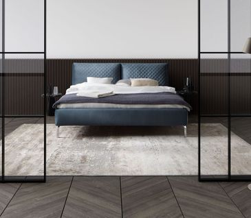 Blaues Polsterbett vor weißer Wand mit braunen Kacheln