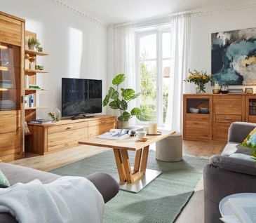 Hölzerner Couchtisch mit modernem Gestell vor einem Lowboard aus Massivholz