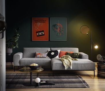 Wohnzimmer im Ethno Style mit grauem Ecksofa und bunter Deko