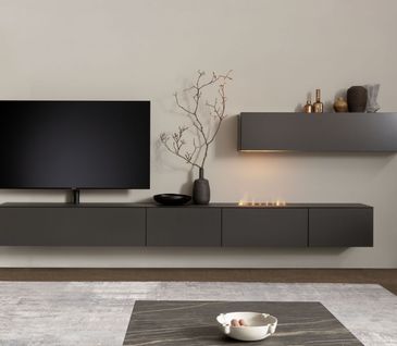 Wohnwand in Schwarz mit wenigen Deko-Elementen wie einer Vase mit Ästen