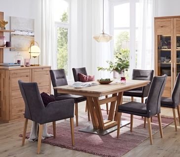 Esszimmer mit grauen Lederstühlen und einem Esstisch aus Massivholz