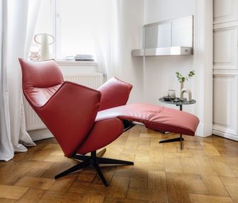 Ein roter Fernsehsessel in Relaxposition in einem hellen Wohnzimmer