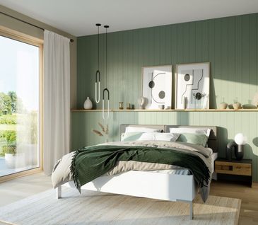 Schlafzimmer mit hellgrüner Wand und großem Fenster. Breites Bett mit grauer und dunkelgrüner Tagesdecke und Beistelltisch.