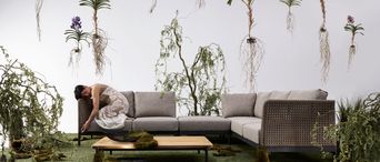 Lounge-Sofa für die Terrasse mit Loungetisch in künstlerischer Outdoor-Kulisse.