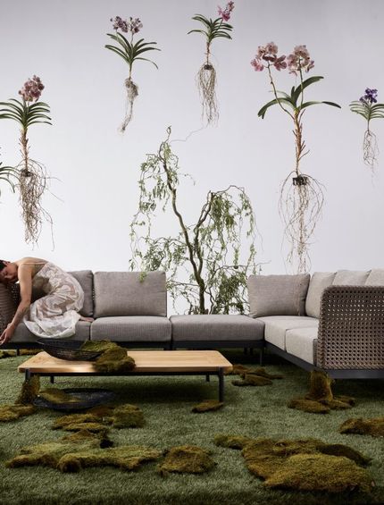 Lounge-Sofa für die Terrasse mit Loungetisch in künstlerischer Outdoor-Kulisse.