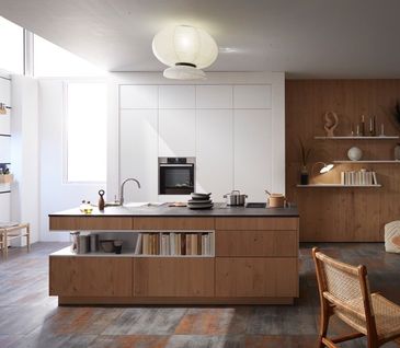 Inselküche mit weißer Küchenzeile und Küchenblock mit Holzfronten.