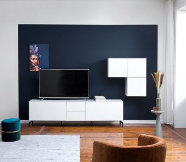 Weißes Lowboard vor einer dunkelblau gestrichenen Wand im Wohnzimmer