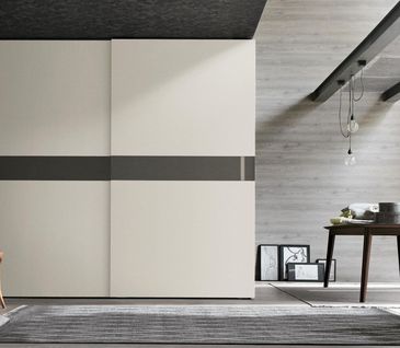 Weißer Schwebetürenschrank mit schwarzen Akzenten in einem modernen Schlafzimmer.