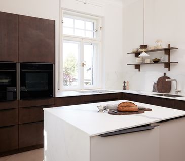 Moderne Küche im Japandi-Stil mit dunklem Holz und weißer Arbeitsplatte.