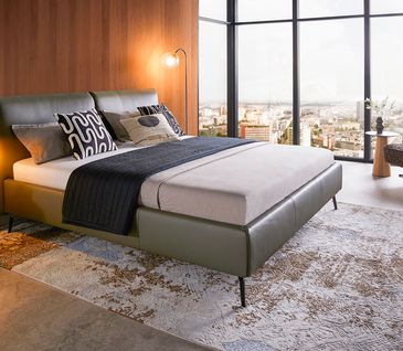Elegantes Polsterbett mit Lederbezug in der Farbe Olive in moderner Loft-Wohnung.