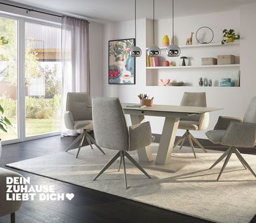 Modernes Esszimmer mit minimalistischer, hellgrauer Einrichtung: Esstisch und Armlehnstühle in Hellgrau auf beigem Teppich.