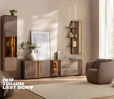 Wohnwand aus Buche mit Lowboard, Hängeregal und Vitrine mit integrierter Beleuchtung.