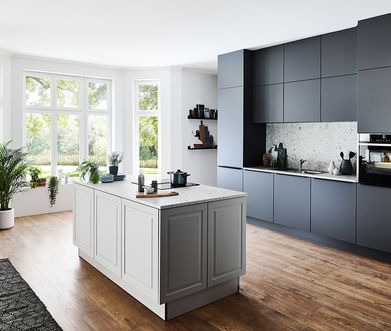 Große, moderne Inselküche mit schwarzer Küchenzeile und weißer Kücheninsel.