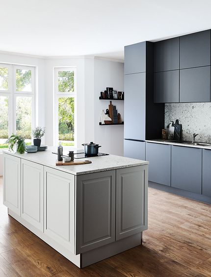 Große, moderne Inselküche mit schwarzer Küchenzeile und weißer Kücheninsel.