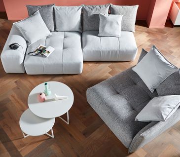 Vogelperspektive auf modernes Wohnzimmer mit grauem modularen Sofa - auch als Einsitzer.