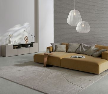 Daybed mit großer Liegefläche in gelbem Stoff in weitläufigem Wohnzimmer.
