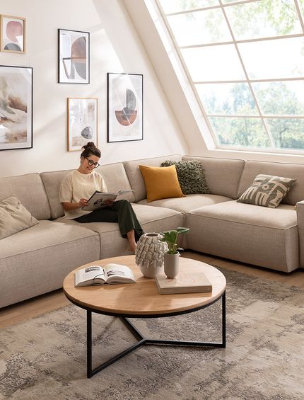 Großes beiges Ecksofa in minimalistischem Stil in modernem Wohnzimmer mit Dachschräge.
