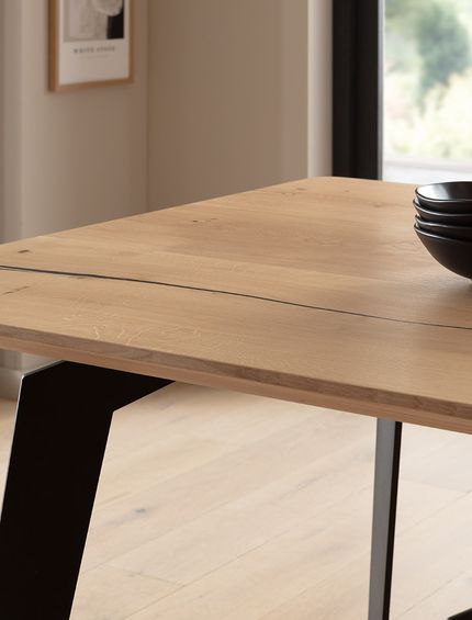 Moderner Esstisch mit Eichenplatte und schwarze Metallgestell.