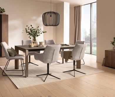 Hell eingerichtetes Esszimmer mit großem Holztisch, Esszimmerstühlen in beigem Bouclé und Holzmöbeln für Stauraum.