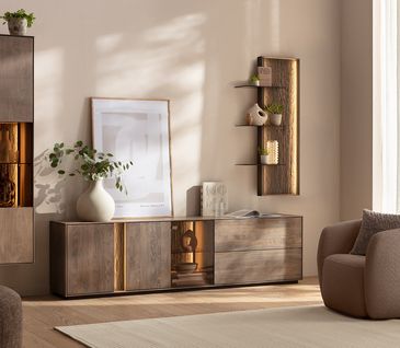 Wohnwand mit Beleuchtung aus Buchenholz in hellem Wohnzimmer mit braunem Sessel und beigem Teppich.