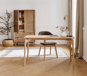 Schreibtisch aus Holz mit passendem Stuhl und Highboard in modernem Arbeitszimmer.
