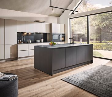 Minimalistische Inselküche mit schwarzer Kücheninsel und Küchenzeile in Hellgrau.