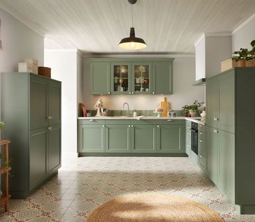 L-Kueche im modernen Landhausstil in der Farbe Eukalyptus Grün.