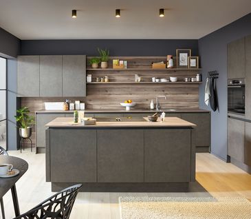 Inselküche mit Kücheninsel in grauer Beton-Optik mit passender Küchenzeile und offenem Essbereich.