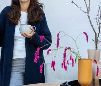 Viele kleine Tipps zum Thema Nachhaltigkeit Wohnen lassen sich gut im Alltag umsetzen. Interior Stylistin Nicole Zweig steht vor rundem Esstisch.