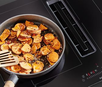 Gemüsepfanne auf Induktionskochfeld mit integriertem Dunstabzug