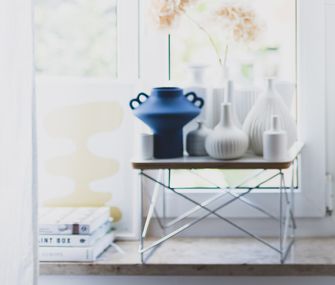 Helles Fenster und Fensterbank, die mit Vasen und Coffee Table Books dekoriert ist