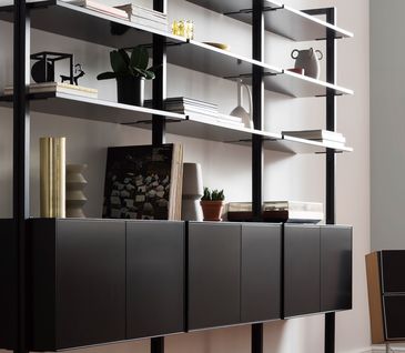 Filigranes schwarzes Wandregal dekoriert mit verschiedener Dekoration