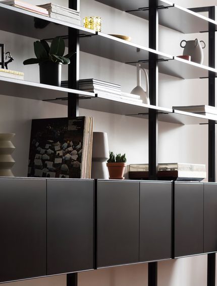 Filigranes schwarzes Wandregal dekoriert mit verschiedener Dekoration