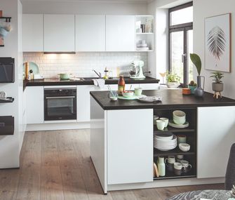 Helle Küche mit Holzboden und dunklen Arbeitsplatten und Kücheninsel