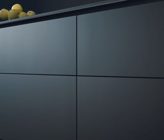 Küchenfront von schwarzer Küche mit Obstkorb auf Arbeitsplatte