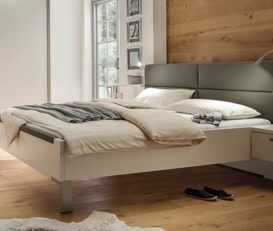 Weißes Bettgestell mit grauem gepolsterten Kopfteil im modernen Schlafzimmer