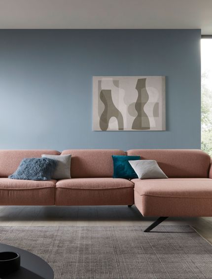 Pinkfarbiges Sofa mit blauer Wand im Wohnzimmer