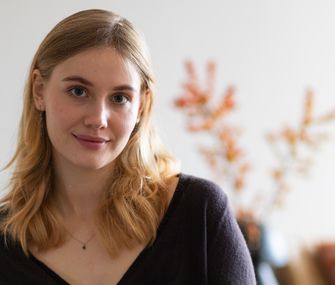 Blonde, junge Frau (Tochter von Nicole) sitzend vor herbstlicher Dekoration