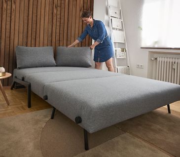 Graues, ausgeklapptes Schlafsofa Per von RAUM.FREUNDE mit schwarzen Metallfüßen