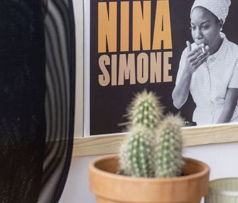 Deko-Kaktus und kleine Vasen vor einem Nina Simone Poster