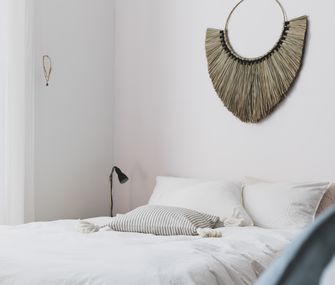 Sommerliches Schlafzimmer mit Bett und Wanddeko